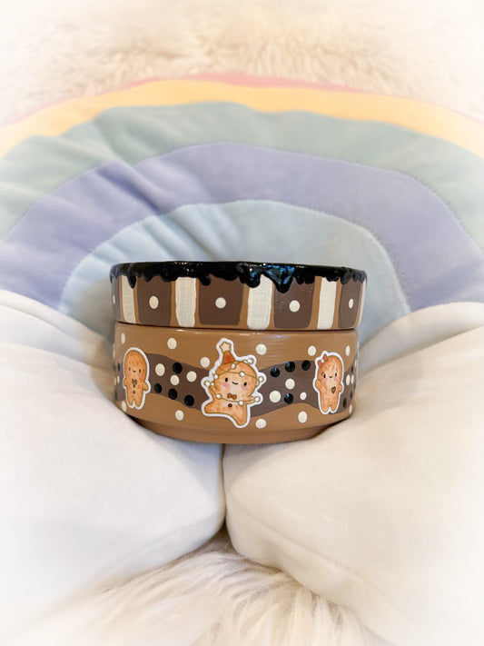 Ceramic trinket tray with gingerbread characters on a soft beige and brown multicolored background to look like cookies